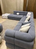 غرفة معيشة بابلز بتصميم حرف L مودرن مع فوتيه أنيق وخشب زان طبيعي وجودة عالية في التشطيب.